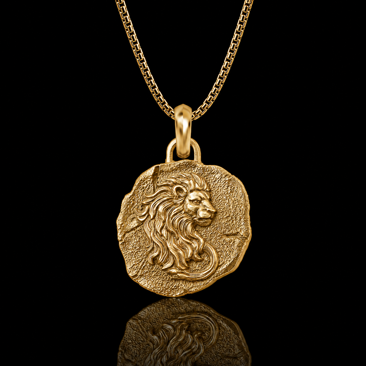 A gold pendant necklace featuring an ancient-style coin medallion with a detailed lion head profile, suspended from a gold chain against a solid black background with a reflection below.