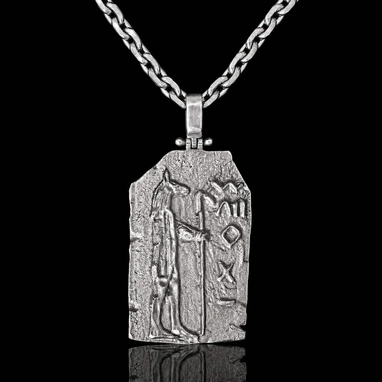 A silver pendant necklace featuring an ancient Egyptian-style hieroglyphic plaque with a pharaoh figure, suspended from a thick chain against a solid black background.