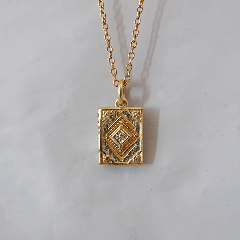 Next Chapter solid gold book charm with ornamental cover and a natural diamond